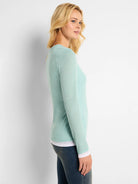 Light teal long-sleeve shirt; double layer, white underlayer visible at cuffs and hem.