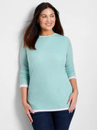 Light teal long-sleeve shirt with white underlay at neckline and cuffs.