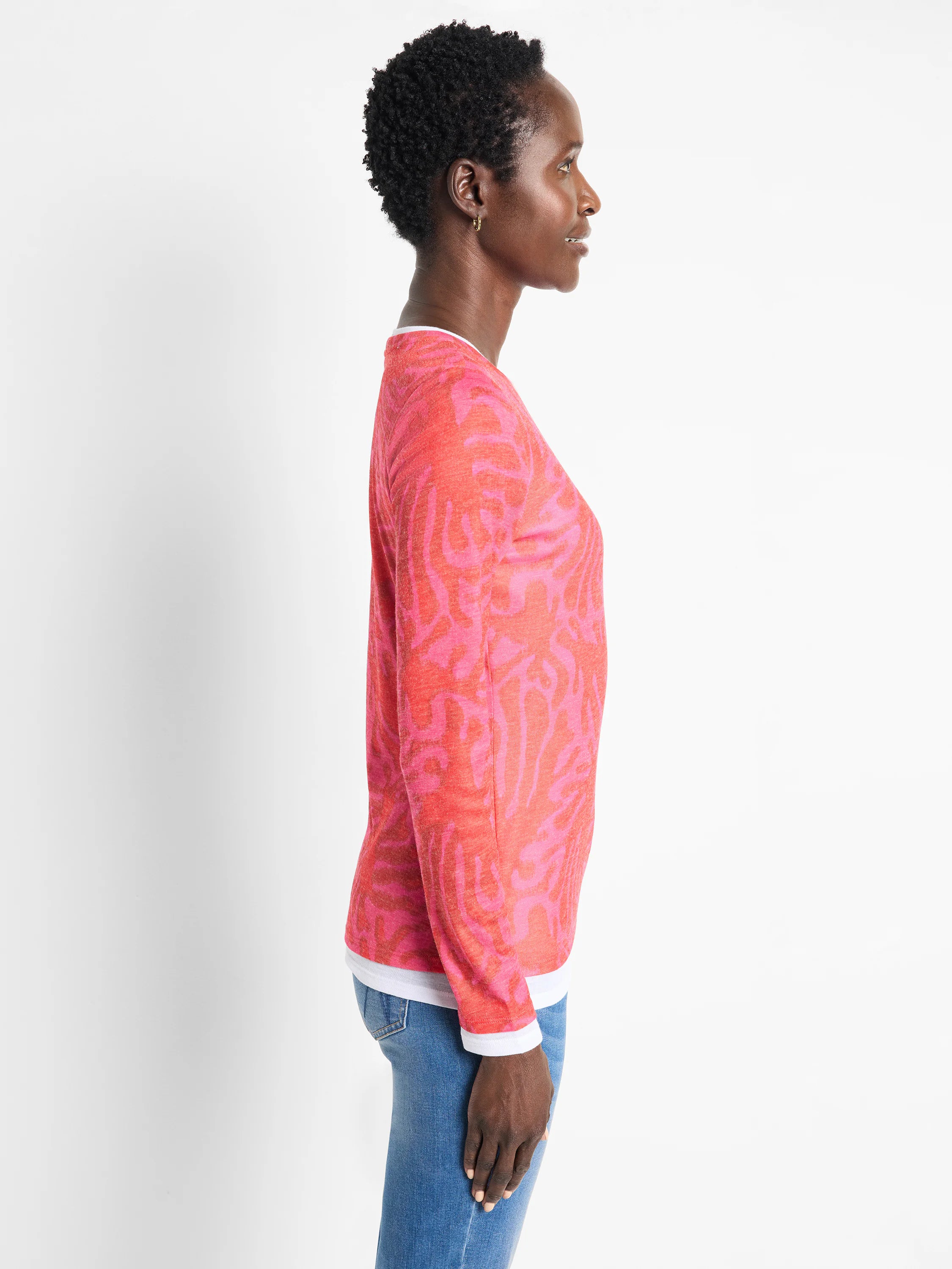 Pink long-sleeve top with darker pink leaf pattern. White underlayer visible at neckline and cuffs.