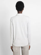 White long-sleeve polo shirt with thin, light blue horizontal stripes.  Rear view.