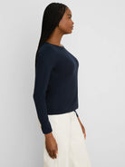 Dark navy ribbed long-sleeve boat neck tee, worn by a woman shown in profile.