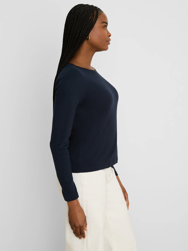 Dark navy ribbed long-sleeve boat neck tee, worn by a woman shown in profile.