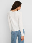 Off-white, ribbed long-sleeve boat tee with a distinct center back seam detail.