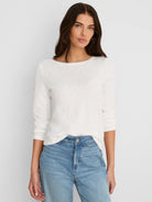 Cream boat neck long-sleeve tee with subtle ribbing.