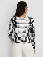 Back view of model in a navy & off-white striped, long-sleeve ribbed boat neck tee.