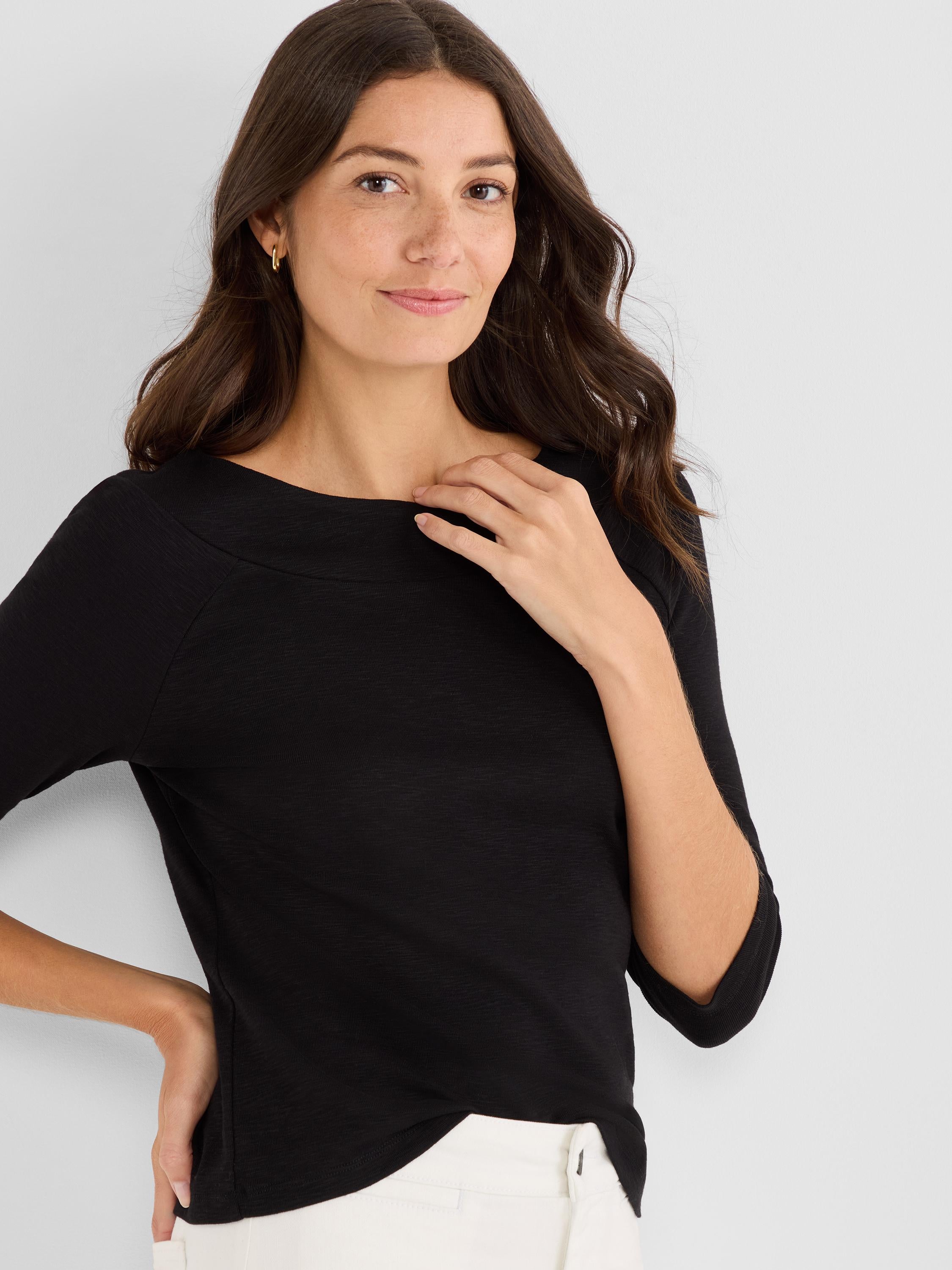 Black knit top with three-quarter sleeves and a wide boat neck features a relaxed fit.