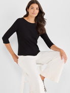 Black fitted knit top with a wide boatneck and elbow-length three-quarter sleeves.