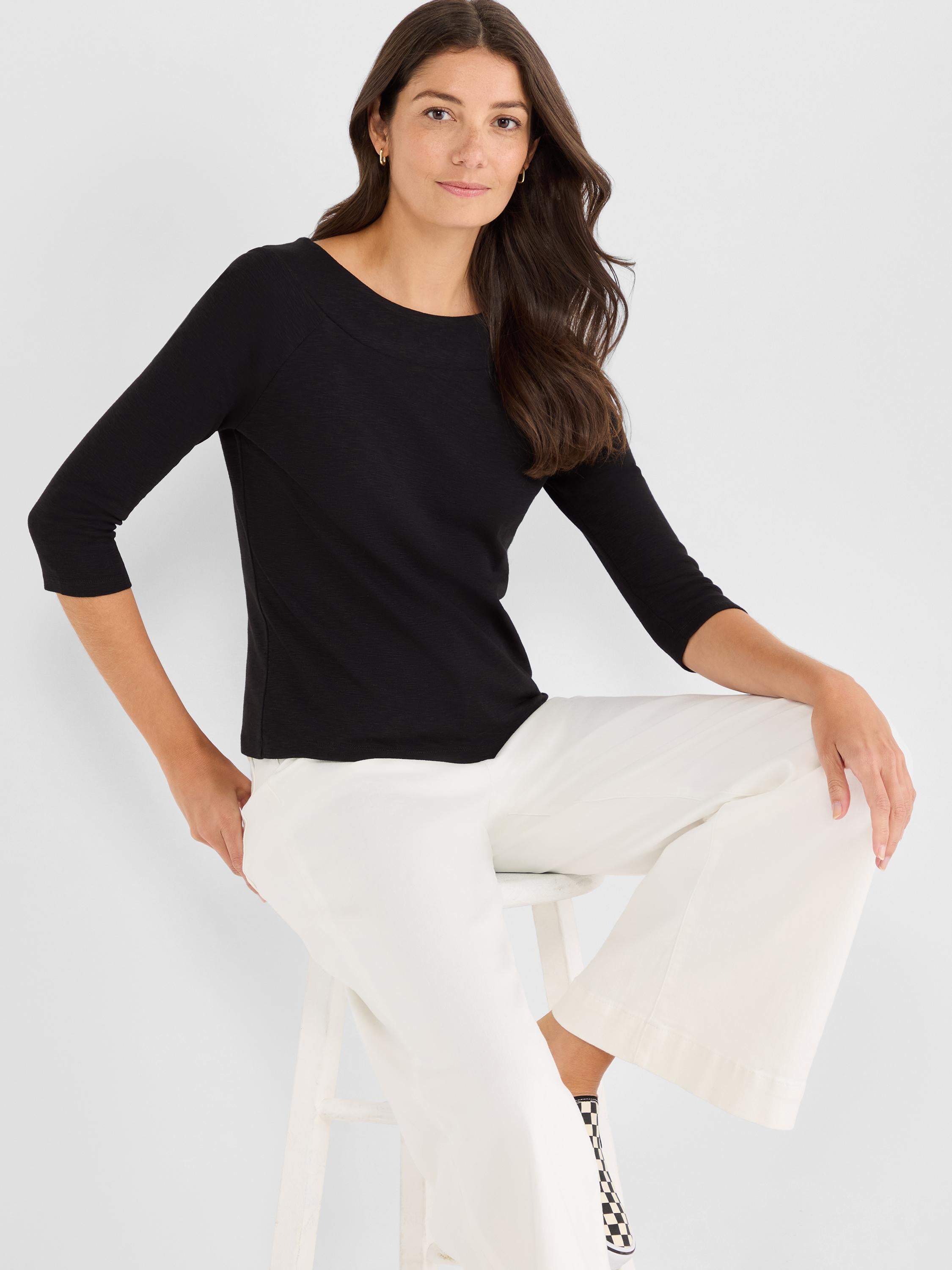 Black fitted knit top with a wide boatneck and elbow-length three-quarter sleeves.