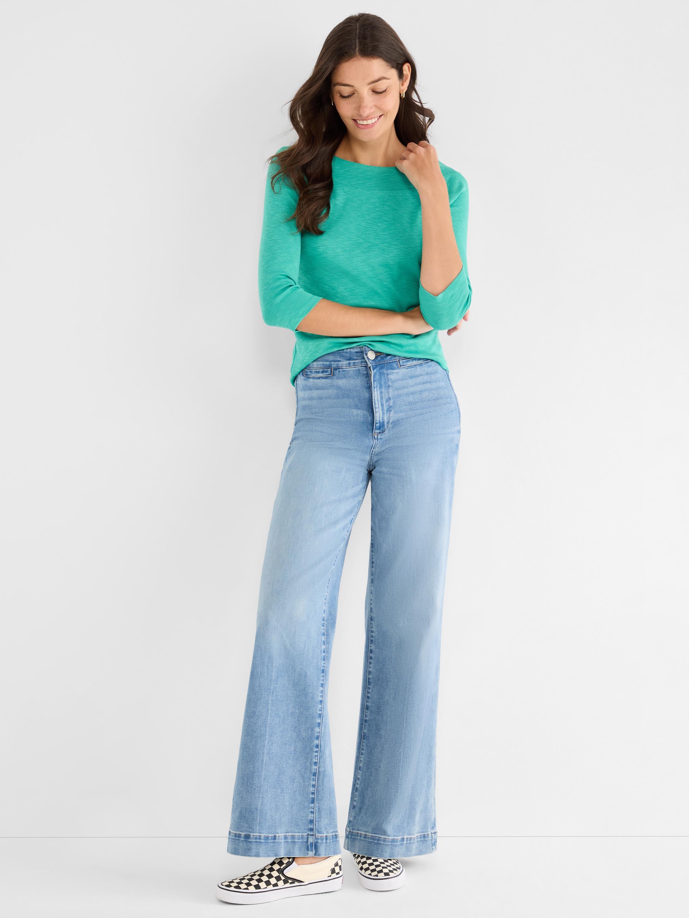The look features a relaxed teal knit top with 3/4 sleeves and light blue high-rise wide-leg jeans.