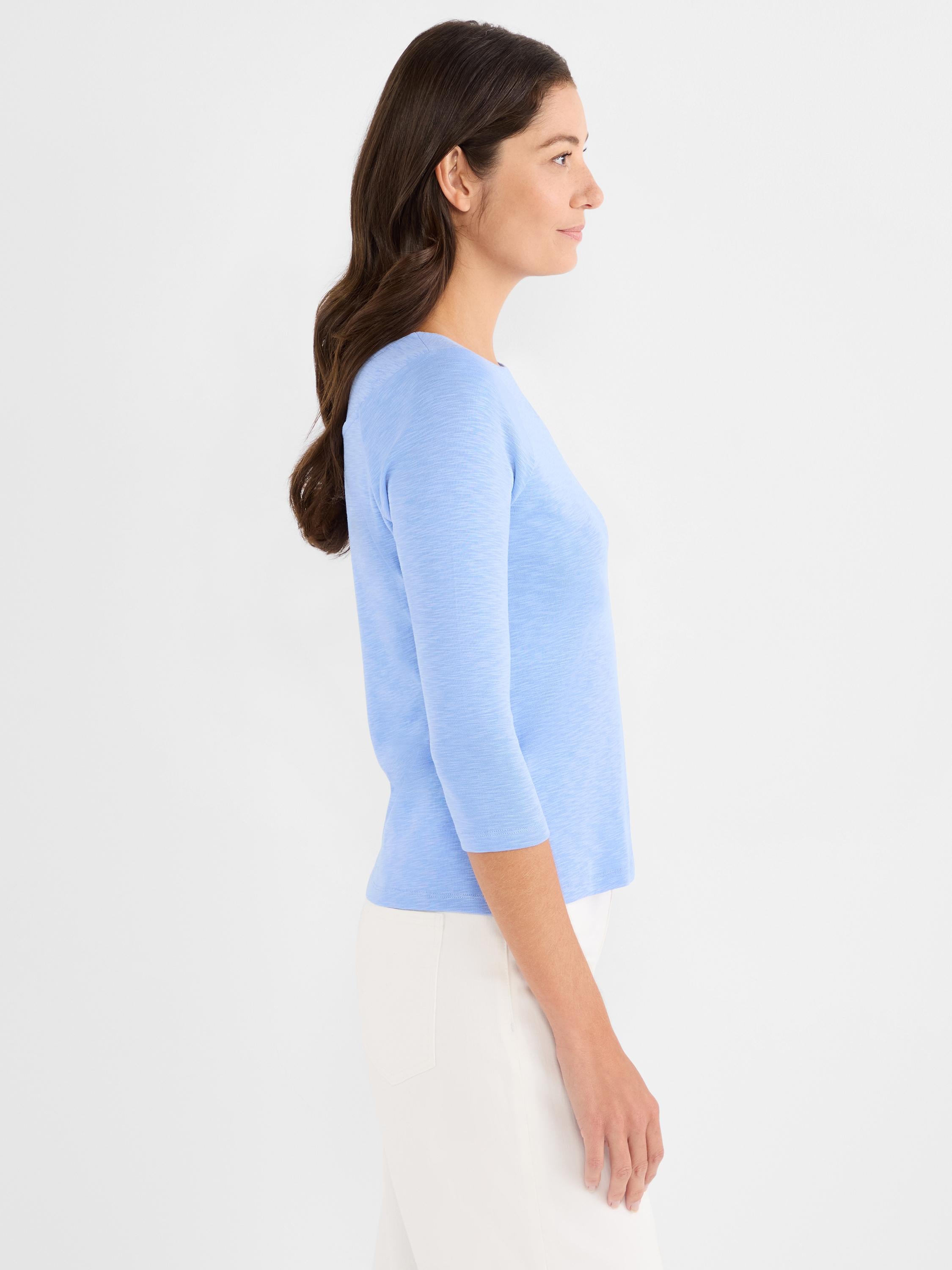 Light blue fitted knit sweater featuring a boat neck and three-quarter sleeves, styled with white pants.