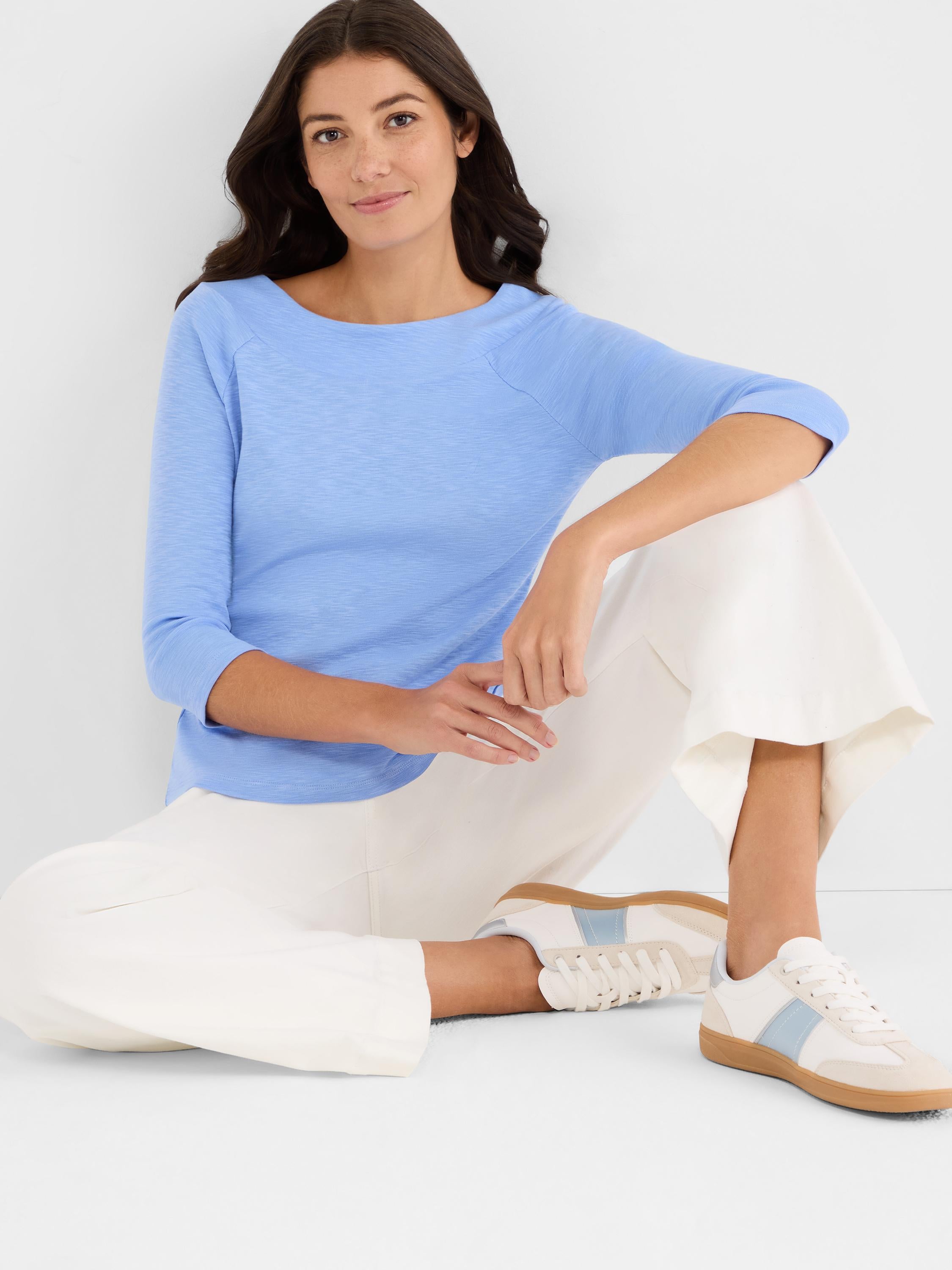 Slim-fit light blue slub knit top featuring a boat neckline and comfortable three-quarter raglan sleeves.