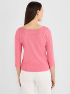 A fitted heather pink 3/4 sleeve top with a curved boat neck is shown worn by the model.