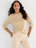 Model wears a relaxed fit beige and tan striped boat neck top with 3/4 sleeves.