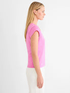 Pink cap sleeve V-neck tee, shown from the side on a model.