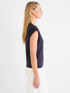 Woman in profile wearing a dark blue cap sleeve V-neck tee. Solid color, fitted style.