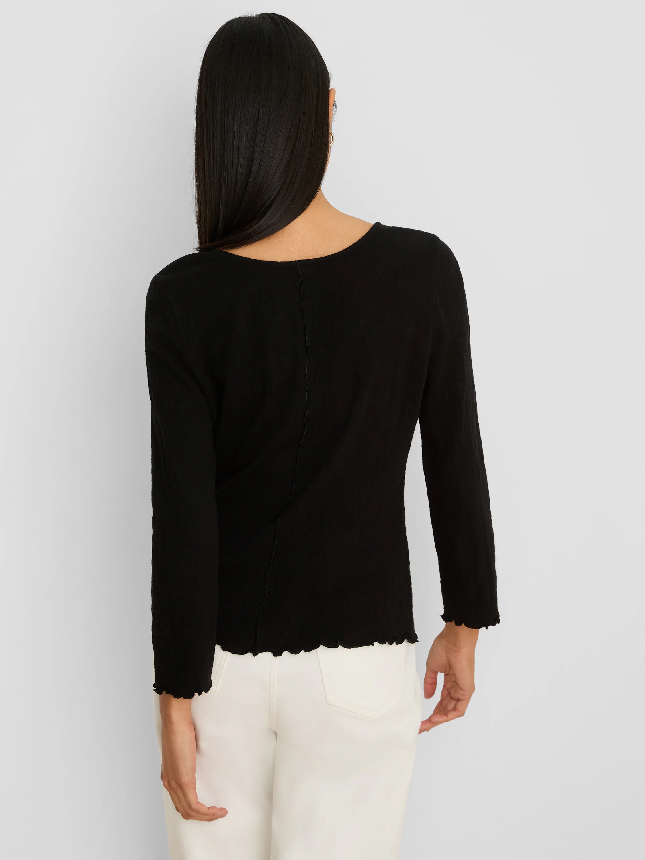Back view: Black 3/4 sleeve lace knit scoop tee with exposed back seam, scalloped raw edges at hem and cuffs.