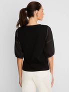 Black cotton tee with sheer linen elbow-length sleeves and white contrast stitching. Back view on model.