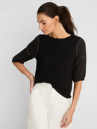 Black tee with short, puffed linen sleeves. White contrast stitching outlines shoulder seams and gathered cuffs.