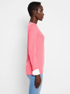 Pink long-sleeved top with white double-layered cuffs.  Profile view.