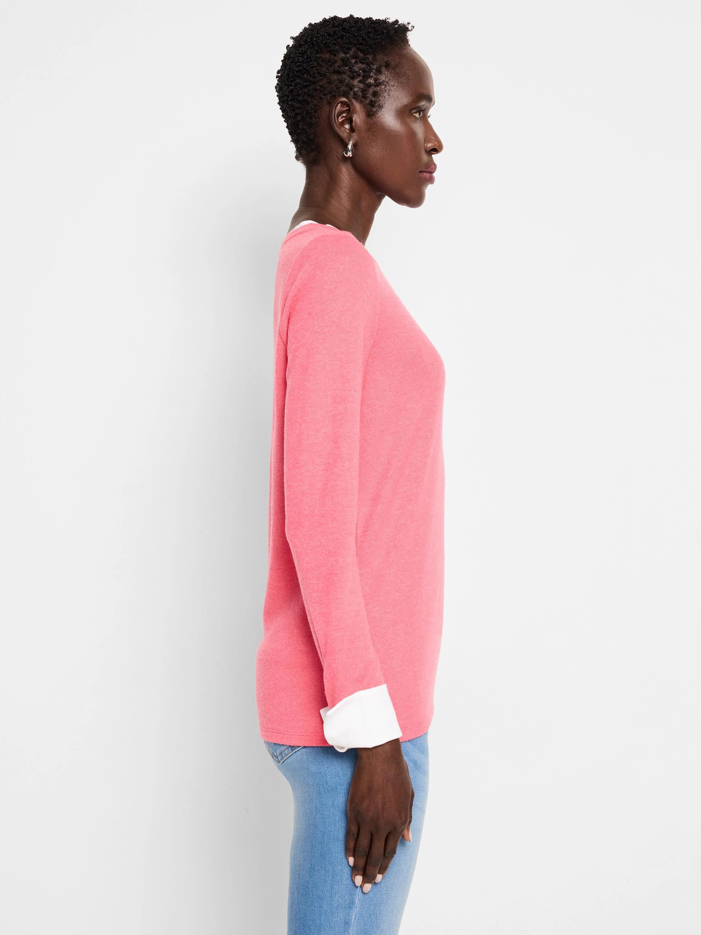 Pink long-sleeved top with white double-layered cuffs.  Profile view.