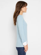 Light blue double-layered top with white cuffs.  Long sleeves.