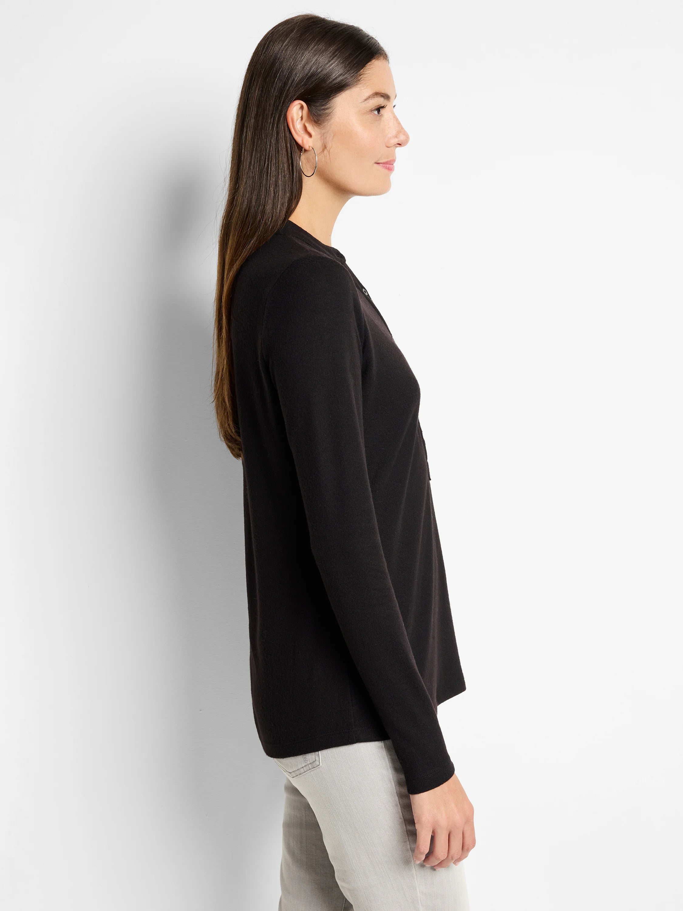 Black long-sleeve henley shirt; side profile.  The shirt has a henley neckline and is shown on a model.