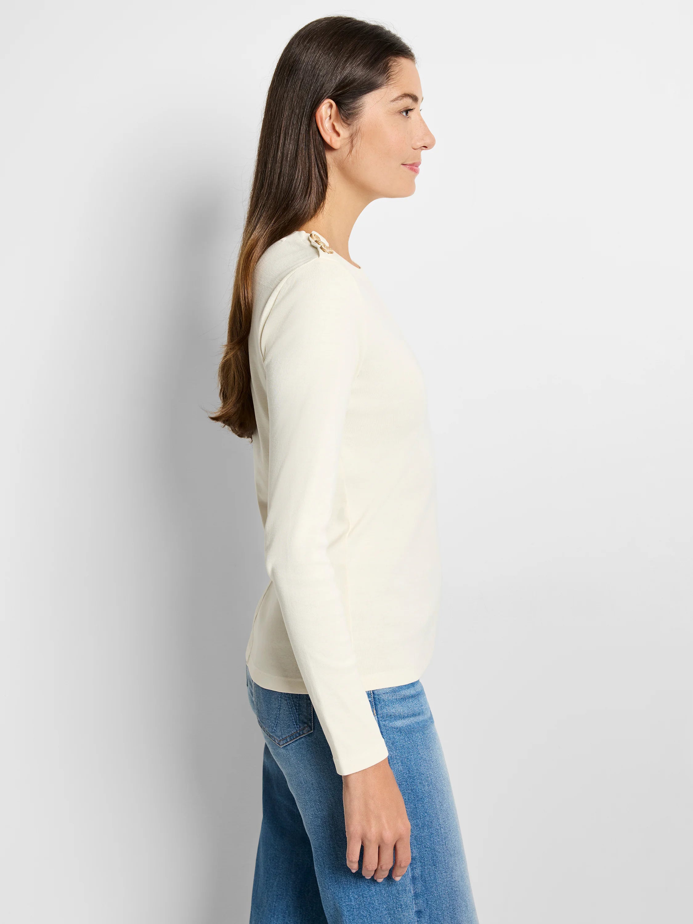 Off-white long-sleeve top with gold buttons on the shoulder.  Side profile view.