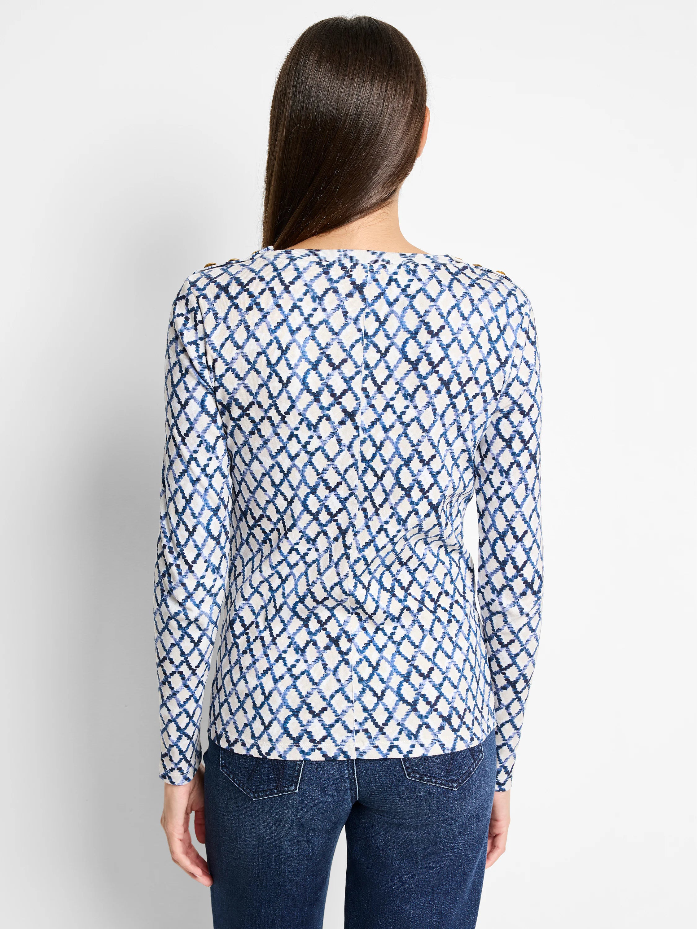 Long-sleeve top, off-white background with blue diamond pattern.  Gold buttons on shoulders.