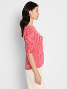A slim red and white striped knit top featuring three-quarter ruched sleeves.