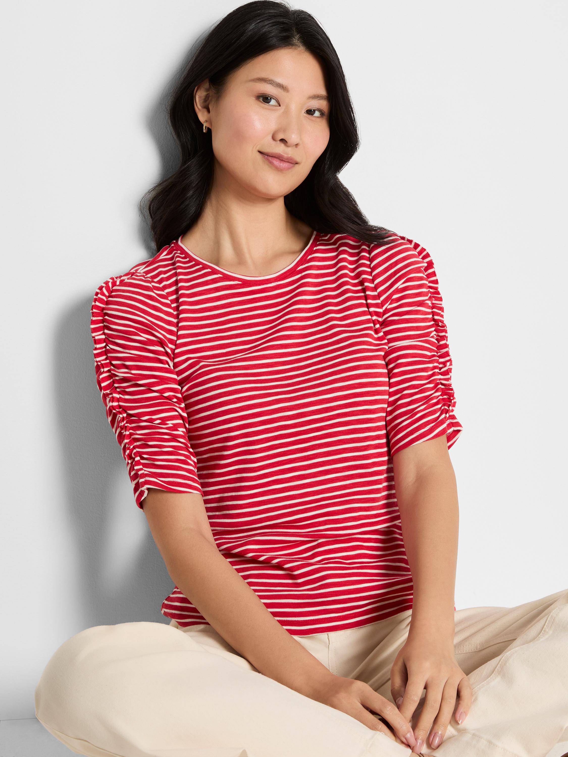 A fitted red and white striped knit top with a round neck and gathered, elbow-length ruched sleeves.