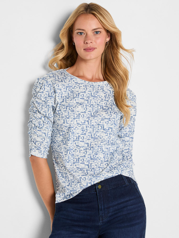 Blue and white abstract print knit top with a scoop neck and ruched three-quarter sleeves.