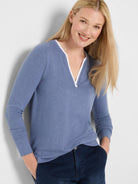 Periwinkle blue jersey tee with long sleeves and a white-trimmed split V-neck.