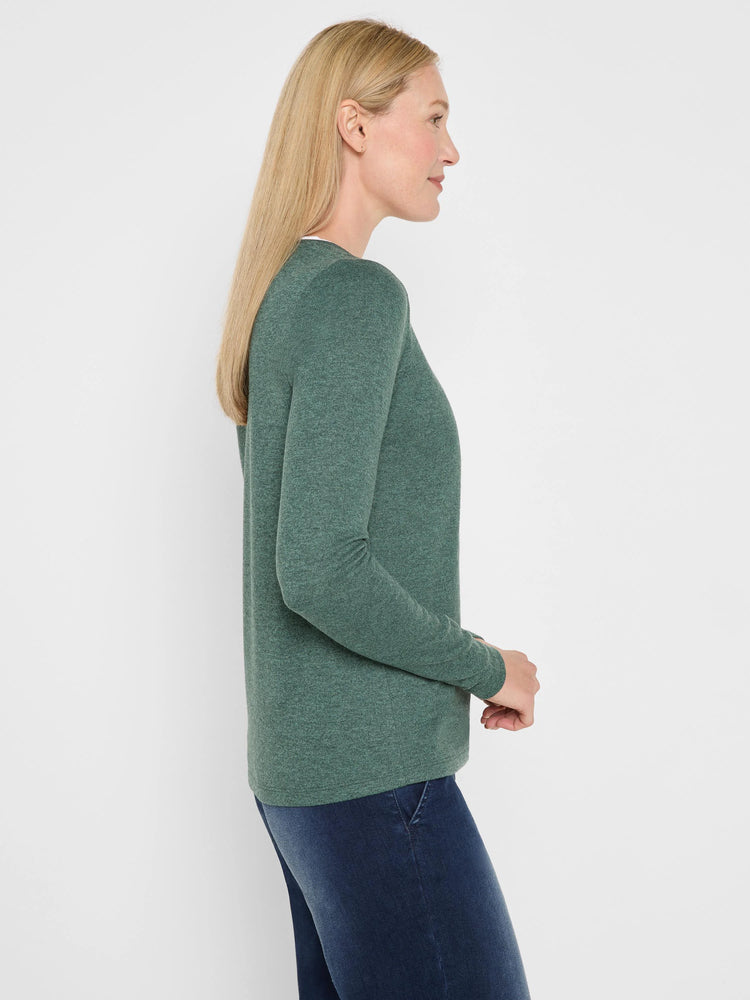 Heathered dark green long-sleeve jersey tee on woman, side profile, with a visible double-layer neckline.