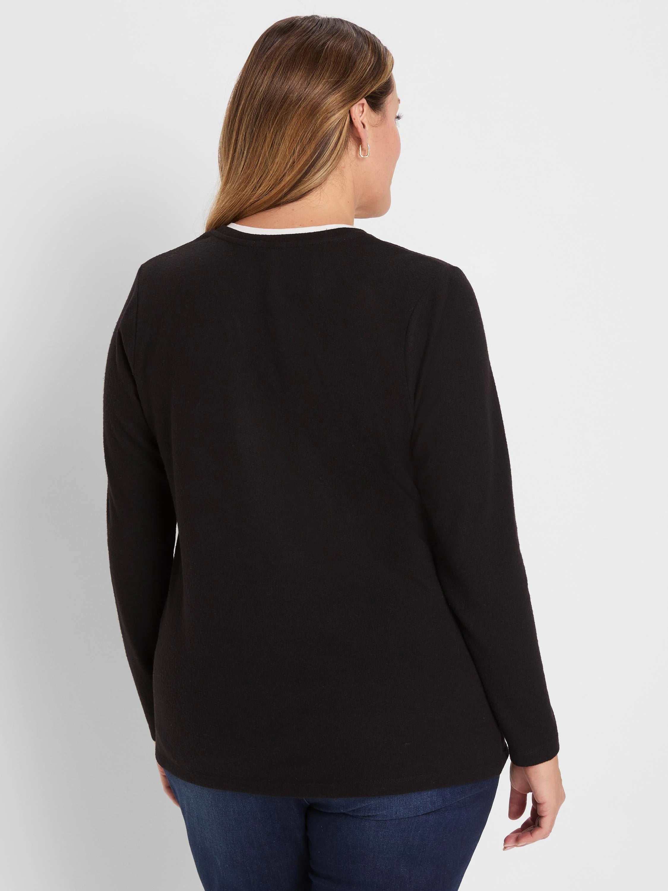 Black long-sleeve tee with white double-layer neckline, seen from the back on a model.