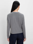 Gray ribbed long-sleeve top with white layer at crew neck.