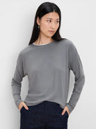 Grey ribbed long-sleeve top with a white double layer visible at the crew neck.