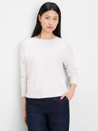 Off-white ribbed long-sleeve top with round neck.