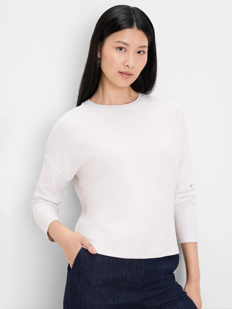 Pale cream ribbed top with round neck, long sleeves, and double-layer neckline detail.