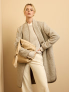 Light beige herringbone top coat with textured fabric and dark brown trim.