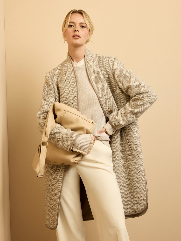 Light beige herringbone top coat with textured fabric and dark brown trim.