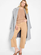 Gray wrap coat, light brown sweater, and tan pants.  Model shown for scale.