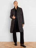 Mid-length dark gray jacquard coat with light flecks, subtle herringbone pattern, black trim on edges, and front buttons.