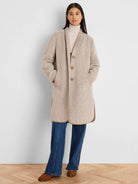 Light beige jacquard top coat. Collarless, mid-thigh length, with tan piping detail and three brown buttons.