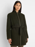 Deep green reversible coat with herringbone texture, lighter olive trim, wrap front, and tied belt.
