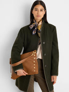 Olive green wool top coat with herringbone pattern, dark trim, and dark buttons.