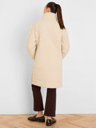 Cream mixed media puffer parka with a high collar and scalloped quilting.