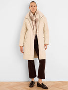 Light beige mixed media parka with quilted body, knit ribbed side panels, knit collar, and front zipper.