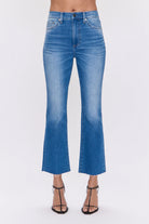 Medium blue high-rise crop bootcut jeans with a frayed hem.