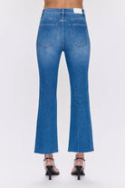Medium blue denim high-rise crop boot jeans, back view, with subtle fading, back pockets, and raw frayed hems.