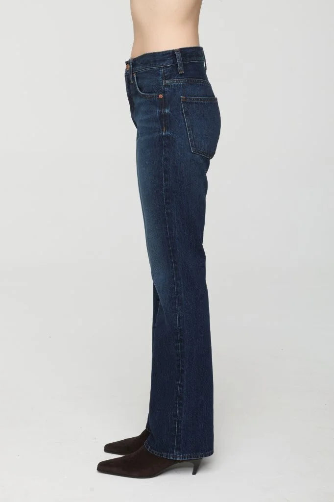 Dark blue denim high-rise bootcut jeans. Side view shows front & back pockets.